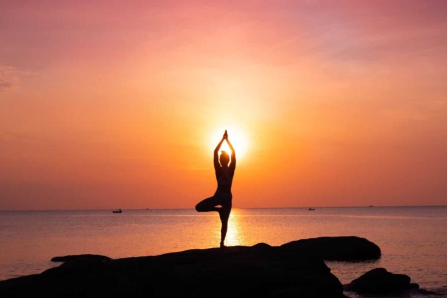 Uno splendido scatto di una ragazza che medita davanti al mare