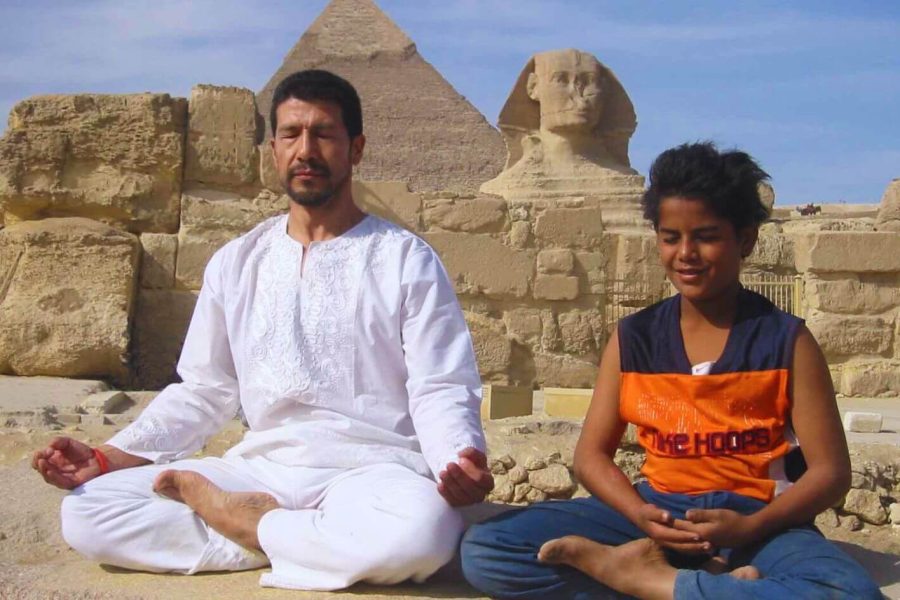 uno scatto meraviglioso di un padre e di suo figlio che si rilassano davanti alle piramidi di Gigi